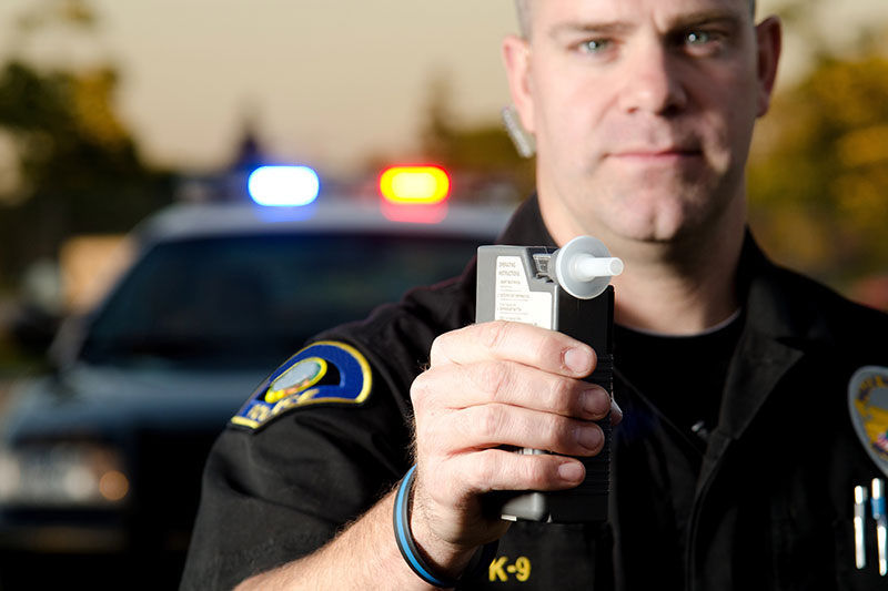 Cop holding a breathalizer